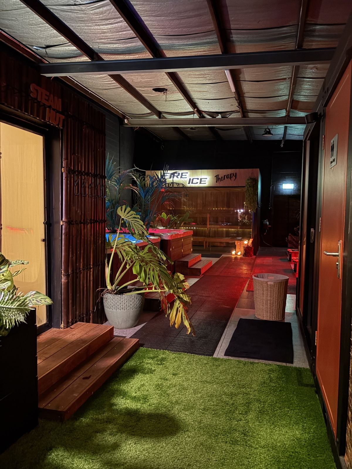 Entry path with green turf leading into the red-lit lounge