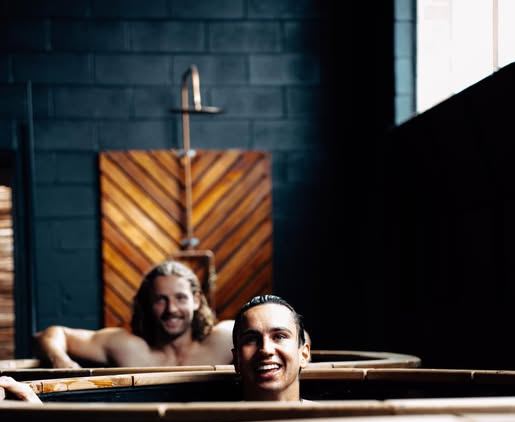 Two friends laughing in the cold plunge